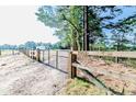 A wooden fence and gate with a house in the background in a rural setting at 3987 Swanns Station Rd, Sanford, NC 27332
