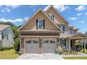Close-up of home's two-car garage with stone accents and lovely landscaping at 50 Turner Mathews Ct, Spring Lake, NC 28390