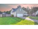 Well-manicured single Gathering home with attached garage, fenced yard, and beautiful green lawn at 109 Shelby St, Spring Lake, NC 28390