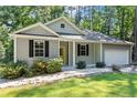 Charming single-story home with gray siding, black shutters, a welcoming yellow front door, and an attached two-car garage at 1541 Louisiana, Sanford, NC 27332