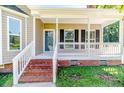 Inviting front porch with brick steps and white railing, perfect for relaxing at 4101 Carson Dr, Sanford, NC 27332