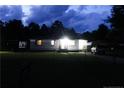 Night shot of single-story home with carport, trailer and an American flag at 411 Rainey Dr, Spring Lake, NC 28390