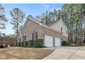 Brick home showing two-car garage, manicured shrubbery, and concrete driveway at 61 Fountain Park Cir, Spring Lake, NC 28390