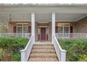 Brick stairs and white railing lead to a covered porch and red front door at 61 Fountain Park Cir, Spring Lake, NC 28390