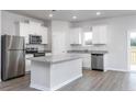 Modern kitchen featuring stainless steel appliances, a center island, and granite countertops at 70 Camp Rock Rd, Lillington, NC 27546