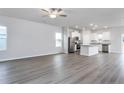 Open-concept living space with sleek floors, a ceiling fan, and a view into the modern kitchen at 70 Camp Rock Rd, Lillington, NC 27546