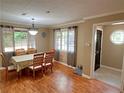 Bright dining area features natural light, a stylish chandelier, and hardwood flooring at 704 Fitts St, Sanford, NC 27330