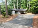 Cozy single-story home with a long driveway and lots of mature trees surrounding the property at 704 Fitts St, Sanford, NC 27330