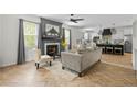 The stylish living room features a fireplace, herringbone floors, and flows into the kitchen with island seating at 143 Persimmon Tree Dr, Cameron, NC 28326