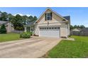 Side view of house with manicured lawn and attached two car garage at 145 Tower Dr, Broadway, NC 27505