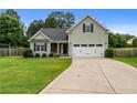 Charming two-story home featuring a manicured lawn, attached two-car garage, and classic curb appeal at 19 Fifty Caliber Dr, Broadway, NC 27505