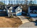 Two-story home featuring a covered porch, attached garage, and a long driveway on a corner lot at 23 Okame Ct, Spring Lake, NC 28390