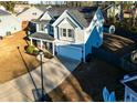 Two-story home with a gray exterior, covered porch, attached garage, and long driveway on a corner lot at 23 Okame Ct, Spring Lake, NC 28390