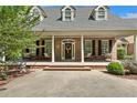 Inviting front porch featuring brick steps and pillars, complete with seating and charming decorative details at 2508 Brighton Pt, Sanford, NC 27330