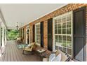 Relaxing front porch with comfortable seating, offering a perfect spot to enjoy the outdoors with brick accents at 2508 Brighton Pt, Sanford, NC 27330
