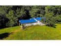Charming home with a blue metal roof and a quaint porch surrounded by green grass and trees at 2708 Nc 87 S Hwy, Cameron, NC 28326
