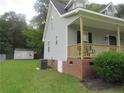 Exterior side view of house featuring brick foundation, storage shed, and green grass at 2734 Sunnybrook Dr, Sanford, NC 27330