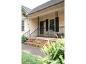 Inviting front porch with railing detail offers a relaxing outdoor seating area, complemented by landscaped beds at 2847 Pickard Rd. Rd, Sanford, NC 27330