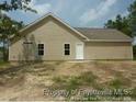Tan single-story home featuring a back patio and a simple back yard at 39 Gold Ct, Broadway, NC 27505