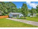 The house has a long driveway and well-manicured lawn, surrounded by mature trees for privacy at 114 Gum Rd, Dunn, NC 28334
