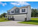 Side view of a two-story home with manicured lawn and a two-car garage at 55 Fern Ridge Dr, Cameron, NC 28326