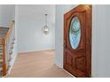 Elegant foyer features wood flooring, a decorative light fixture, and a beautiful wood front door at 1397 Colorado Trl, Sanford, NC 27332