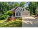 Charming home with lush lawn, brick accents, and two-car garage, nestled among mature trees at 1397 Colorado Trl, Sanford, NC 27332
