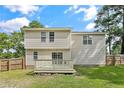 Exterior back of home featuring a wood deck with a large grassy backyard at 69 Ribbon Oak Ct, Sanford, NC 27332