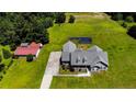 Aerial view of home with outbuilding, basketball court, and well-manicured lawn at 10110 Nc 27 W Hwy, Lillington, NC 27546