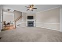 Comfortable living room with a stone fireplace, plush carpet, and a ceiling fan at 34 Westchester Ln, Angier, NC 27501