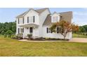 Charming two-story home with a inviting front porch, complemented by lush landscaping and a beautiful tree at 38 Beadle Cts, Smithfield, NC 27577