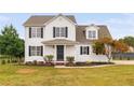 Beautiful two-story home with dark shutters, manicured landscaping, and a covered front porch with ample space at 38 Beadle Cts, Smithfield, NC 27577