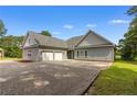 Home featuring a three-car garage, gray siding, and a spacious driveway at 56 Indian Trl, Sanford, NC 27332