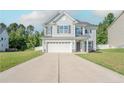 Inviting home with a wide driveway leading to an attached garage and a spacious front yard at 80 Pedley Pl, Cameron, NC 28326