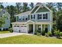 Charming two-story home featuring a two-car garage, lush lawn, and a welcoming front porch at 116 School Side Dr, Spring Lake, NC 28390