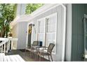 Cozy front porch with seating area, wreath on front door, and natural light from the large front windows at 133 Bonnell Ct, Cary, NC 27511