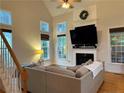 A modern living room with high ceilings, large windows, and a fireplace at 399 Falling Water Rd, Spring Lake, NC 28390