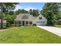 Charming home featuring a well-manicured lawn, a covered porch, and attached two-car garage at 120 Timberwood Dr, Carthage, NC 28326