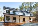 Inviting modern farmhouse exterior featuring a covered front porch with rocking chairs at 1418 Crawford Dairy Rd, Pittsboro, NC 27312