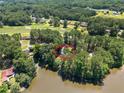 Home is surrounded by mature trees and near a lake in an aerial view at 185 Tree Cutters, Sanford, NC 27332