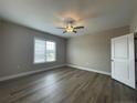 Bedroom features wood-look flooring, ceiling fan, and a bright window at 240 Gallery Dr # 303, Spring Lake, NC 28390