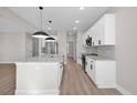 Bright kitchen with white cabinets, granite countertops, stainless steel appliances and sleek pendant lighting at 298 Dove Rd, Cameron, NC 28326