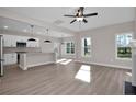 Open-concept living area with gray walls, modern light fixtures, and a view into the kitchen with stainless appliances at 298 Dove Rd, Cameron, NC 28326