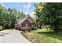 Beautiful stone house featuring a long driveway and lush green lawn at 3027 Carrington Ln, Sanford, NC 27330