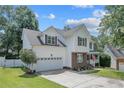 Beautiful two-story home with a spacious two-car garage, brick accents, manicured lawn and charming front porch with a flag at 43 Ambrose Pt, Cameron, NC 28326