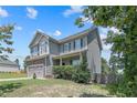 Charming two-story home with stone accents, attached two-car garage, and well-maintained lawn at 442 Kentucky Derby Ln, Lillington, NC 27546