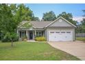 Charming single-story home with a well-maintained lawn, a two-car garage, and a welcoming front porch at 138 Gold Ct, Broadway, NC 27505