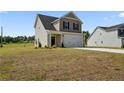 Charming two-story home featuring an attached garage, light beige siding, and a well-maintained lawn at 15 Red Bird Dr, Cameron, NC 28326
