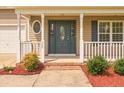 Close up of the front porch featuring white railings, a gray front door and manicured landscaping at 280 Hillandale Rd, Spring Lake, NC 28390