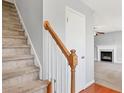 Carpeted staircase with wooden banister leading to the upper level of the home with view of living room at 280 Hillandale Rd, Spring Lake, NC 28390